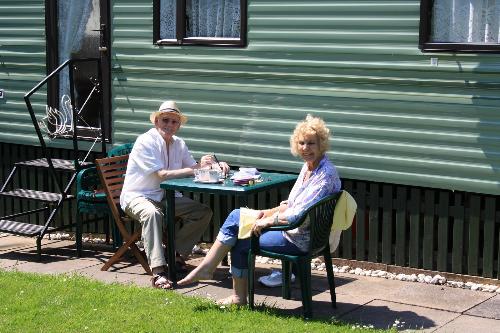 Margaret & Derek enjoying the sun outside their caravan