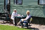 Margaret & Derek enjoying the sun outside their caravan